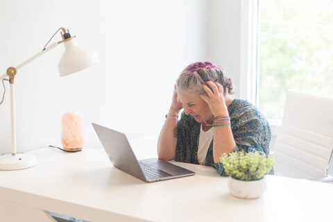 A business owner working on a laptop at a café table